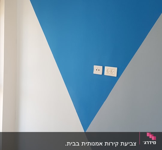 קיר צבוע בצורת משולש כחול ואפור